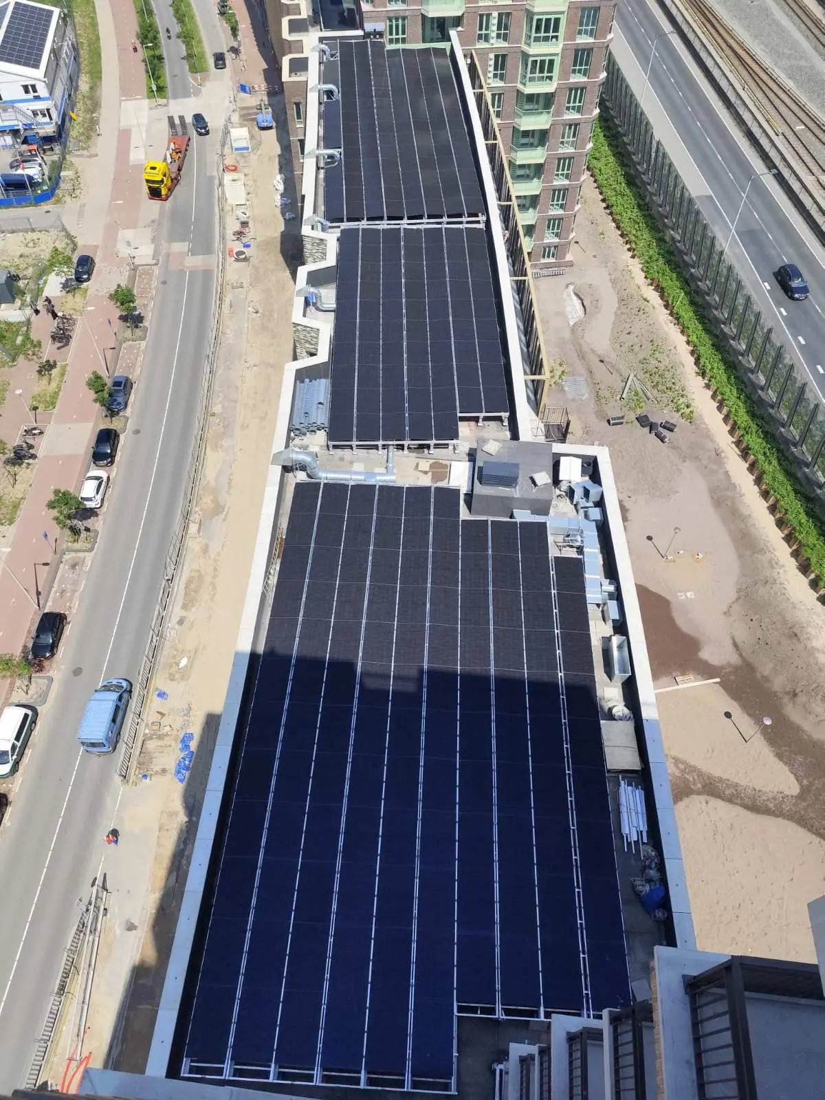 Saulės elektrinė ant daugiabučio stogo mieste iš paukščio skrydžio