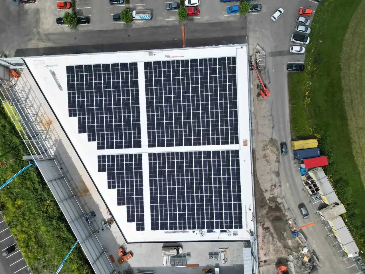 Saulės elektrinė verslui ant didelio komercinio sandėlio stogo iš paukščio skrydžio